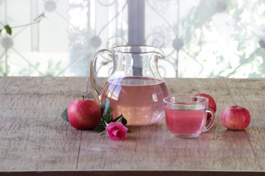 Elma kompostosu şeffaf bir sürahi, taze elma ve bir gül