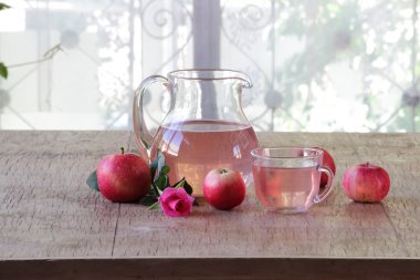 Elma kompostosu şeffaf bir sürahi, taze elma ve bir gül