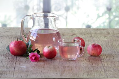 Ahşap bir masa üzerinde şeffaf bir sürahi taze elma kompostosu