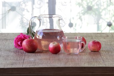 Elma kompostosu, şeffaf bir sürahi taze elma ve bir gül