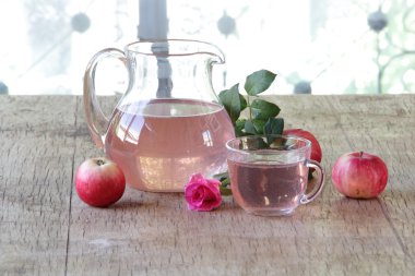 Elma kompostosu, şeffaf bir sürahi taze elma ve bir gül