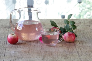 Elma kompostosu, şeffaf bir sürahi taze elma ve bir gül