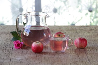 Elma kompostosu, şeffaf bir sürahi taze elma ve bir gül