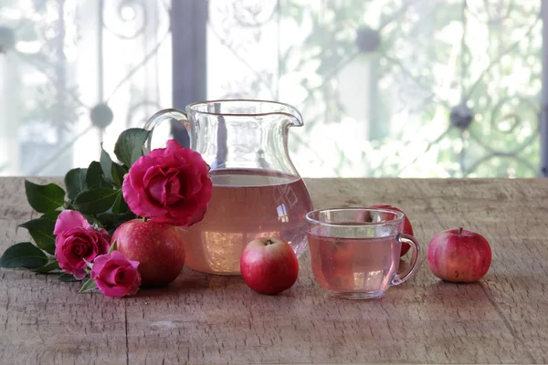 Compota de manzana en una jarra transparente, manzanas y un ramo de rosa —  Fotos de Stock