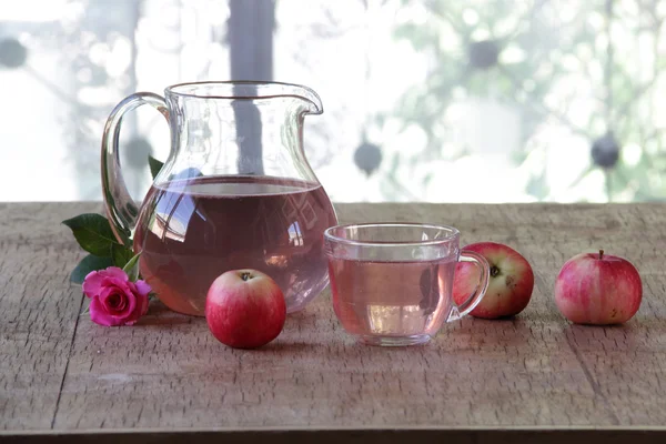 Apple dikomposisi dalam kendi transparan baik apel segar dan mawar — Stok Foto