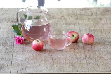 Elma kompostosu, şeffaf bir sürahi taze elma ve bir gül