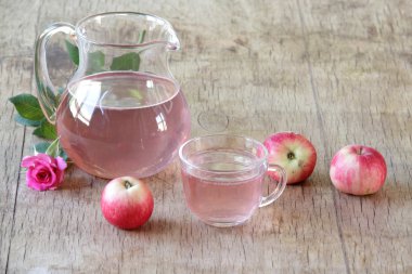 Elma kompostosu, şeffaf bir sürahi taze elma ve bir gül