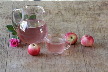 Elma kompostosu, şeffaf bir sürahi taze elma ve bir gül