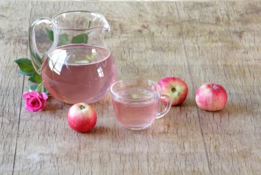 Elma kompostosu, şeffaf bir sürahi taze elma ve bir gül