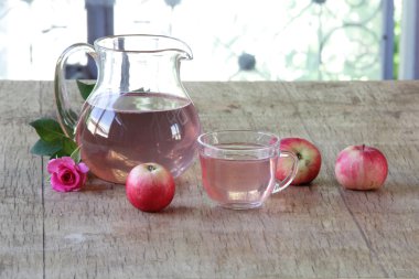 Elma kompostosu, şeffaf bir sürahi taze elma ve bir gül