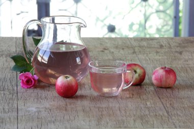 Elma kompostosu, şeffaf bir sürahi taze elma ve bir gül