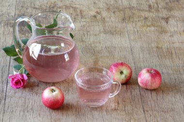 Elma kompostosu, şeffaf bir sürahi taze elma ve bir gül