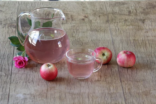 Elma kompostosu, şeffaf bir sürahi taze elma ve bir gül