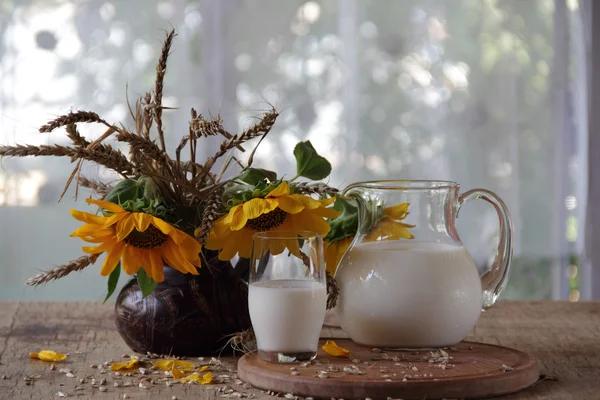 透明な水差し、パンとひまわりの花束のミルク — ストック写真