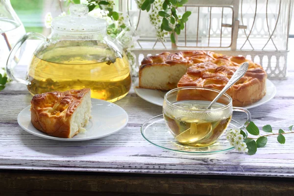 Tea in a transparent cup and a piece of a pie with a stuffing fr — Stock Photo, Image