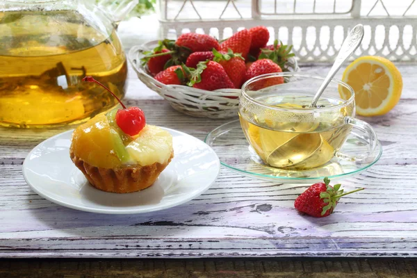 Kuchen mit Früchten und Tee mit Zitrone in einer transparenten Tasse — Stockfoto