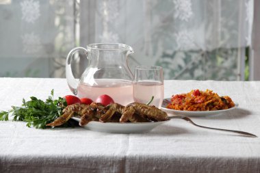 Yeşiller ve sebze ile gönderilmiş bir mangal üzerinde kızarmış tavuk kanadı