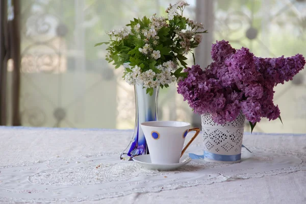 Tee in einer schönen Tasse und ein Strauß aus Zweigen einer Blüte — Stockfoto
