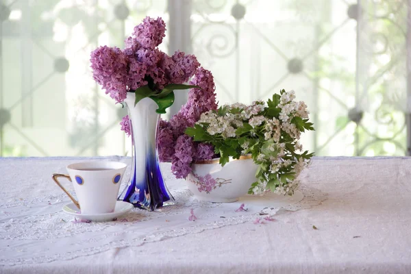 Ramo de una lila y té en una hermosa taza — Foto de Stock