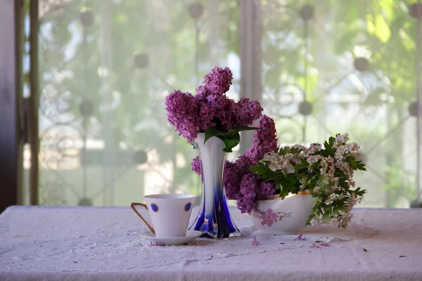 Bouquet von Flieder und Tee in einer schönen Tasse — Stockfoto