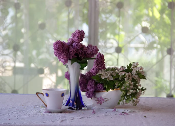 Ramo de una lila y té en una hermosa taza — Foto de Stock