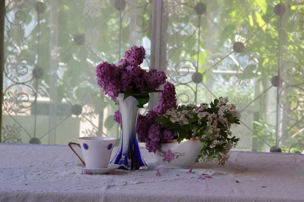 Bouquet von Flieder und Tee in einer schönen Tasse — Stockfoto