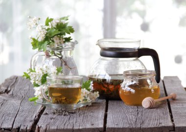 Yeşil çay bir cam bardak, bal ve bir çiçek açması haw Şubesi