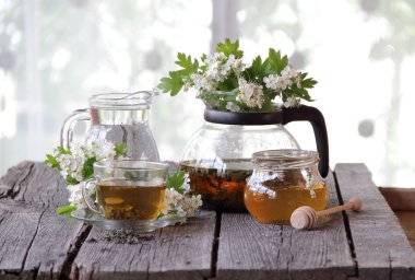 Yeşil çay bir cam bardak, bal ve bir çiçek açması haw Şubesi