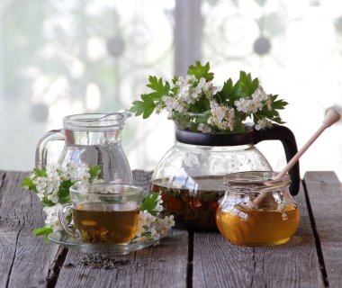 Yeşil çay bir cam bardak, bal ve bir çiçek açması haw Şubesi