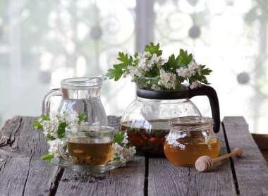 Yeşil çay bir cam bardak, bal ve bir çiçek açması haw Şubesi