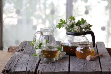 Yeşil çay bir cam bardak, bal ve bir çiçek açması haw Şubesi