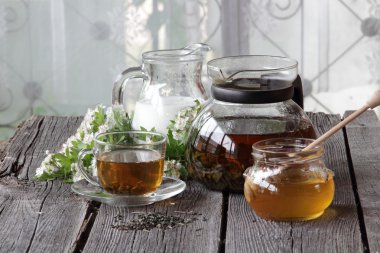 Şeffaf bir fincan ve bir sürahi sütlü çay