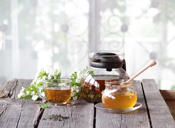 Мед в прозрачном банке и чай в прозрачной чашке — стоковое фото