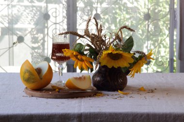 Güzel bir cam, olgunlaşmış kavun ve güneş bir buket kırmızı şarap