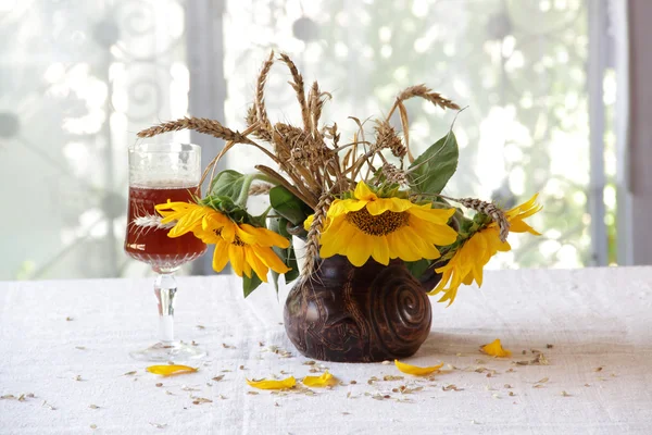 Vino tinto en una hermosa copa y un ramo de girasoles —  Fotos de Stock