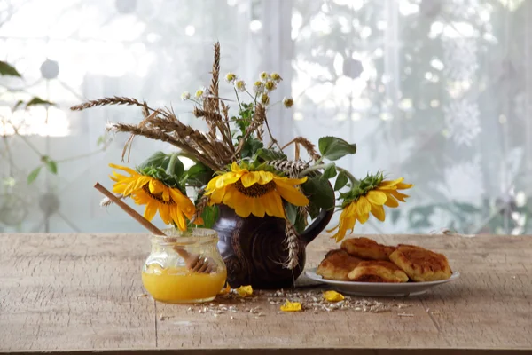 Kaastaart ingediend met honing en een boeket van zonnebloemen — Stockfoto