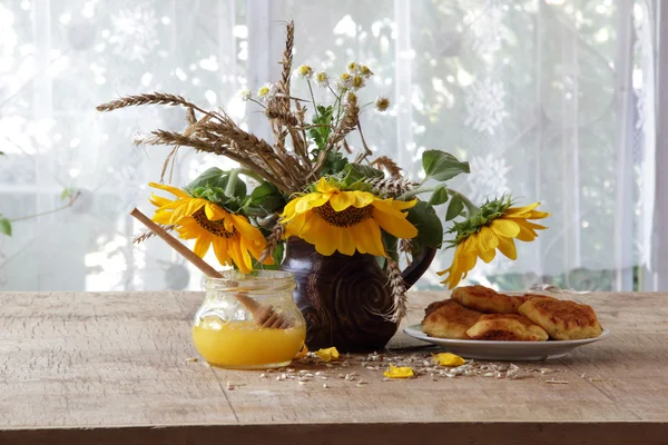 Tartas de queso presentadas con miel y un ramo de girasoles — Foto de Stock