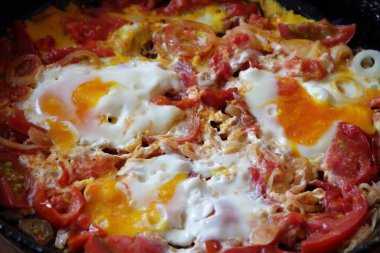 Kızarmış yumurta bir pik demir tavada domates ile