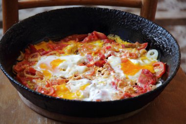 Kızarmış yumurta bir pik demir tavada domates ile