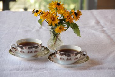 İki bardak kahve ve çiçek demet