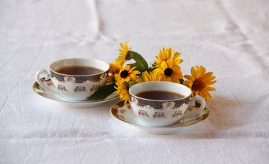 İki bardak kahve ve çiçek demet