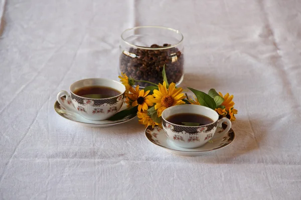 Café en tazas de café y un ramo de flores — Foto de Stock
