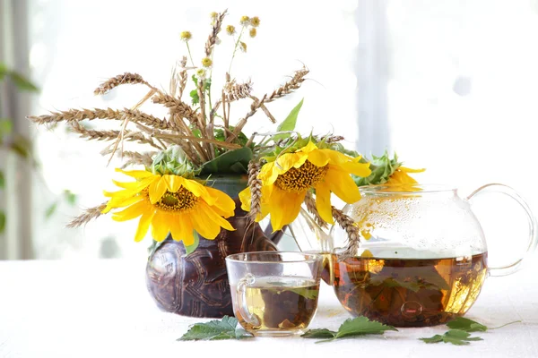 Çay şeffaf bir çaydanlık ve ayçiçeği bir seramik vazoda — Stok fotoğraf