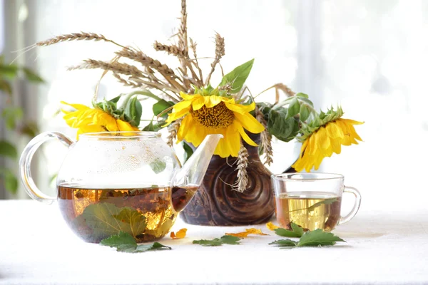 Çay şeffaf bir çaydanlık ve ayçiçeği bir seramik vazoda — Stok fotoğraf
