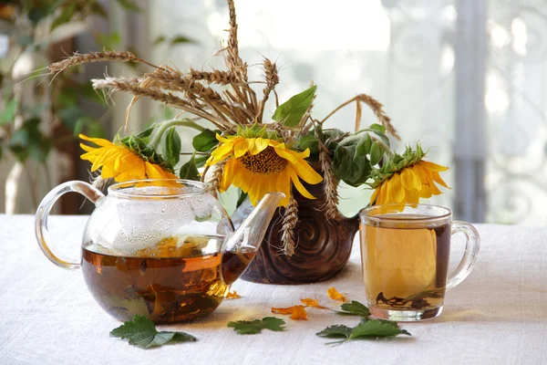 Çay şeffaf bir çaydanlık ve ayçiçeği bir buket — Stok fotoğraf