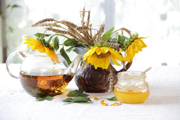 Miel en banco transparente, té y un ramo de girasoles —  Fotos de Stock