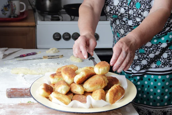 As mãos da mulher idosa põem a torta pronta em um prato — Fotografia de Stock