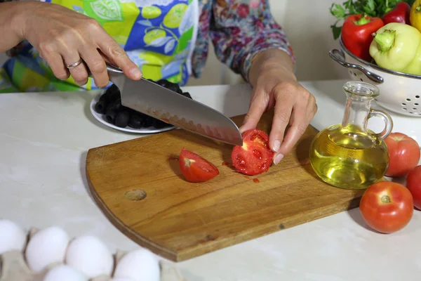 Женщина режет помидор — стоковое фото