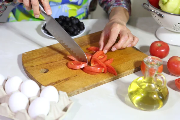 Женщина режет помидор — стоковое фото