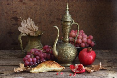 Bir nar, üzüm ve bakır sürahi ile natürmort